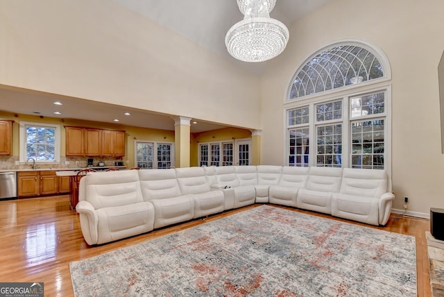 3565 Hickory Branch Trl, Suwanee, GA 30024 - living room featuring high vaulted ceiling, light wood-style flooring, a chandelier, decorative columns, and recessed lighting