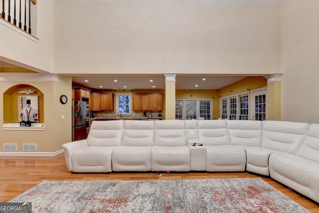 3565 Hickory Branch Trl, Suwanee, GA 30024 - living area featuring ornate columns, a towering ceiling, light wood-type flooring, and recessed lighting