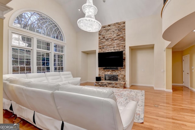 3565 Hickory Branch Trl, Suwanee, GA 30024 - living room featuring high vaulted ceiling, a chandelier, light wood-style flooring, and a fireplace