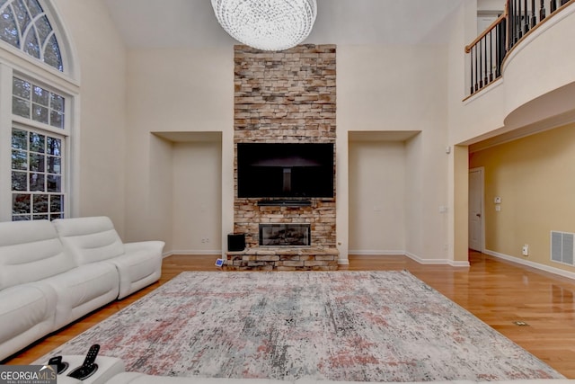 3565 Hickory Branch Trl, Suwanee, GA 30024 - living area featuring a towering ceiling, wood finished floors, a fireplace, and a chandelier