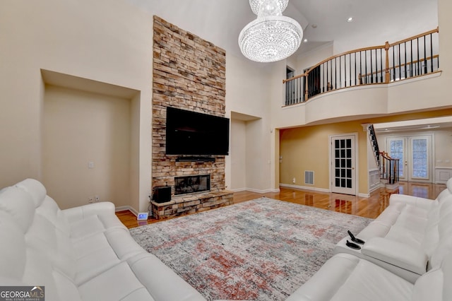 3565 Hickory Branch Trl, Suwanee, GA 30024 - living area with a towering ceiling, wood finished floors, a chandelier, stairs, and a fireplace