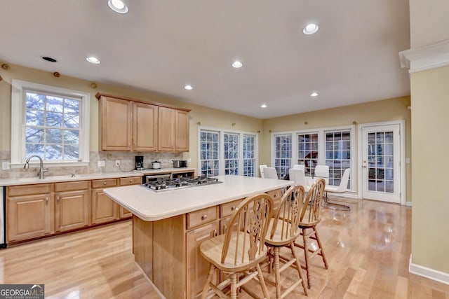 3565 Hickory Branch Trl, Suwanee, GA 30024 - kitchen featuring stainless steel gas cooktop, light brown cabinets, a breakfast bar area, light countertops, and recessed lighting