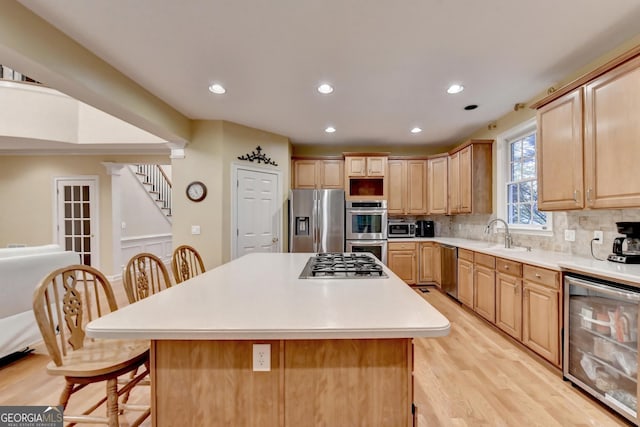 3565 Hickory Branch Trl, Suwanee, GA 30024 - kitchen with stainless steel appliances, wine cooler, a kitchen bar, light wood-style flooring, and tasteful backsplash
