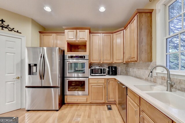3565 Hickory Branch Trl, Suwanee, GA 30024 - kitchen with appliances with stainless steel finishes, light wood-type flooring, light brown cabinets, light countertops, and decorative backsplash