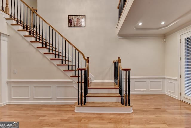 3565 Hickory Branch Trl, Suwanee, GA 30024 - staircase with wood finished floors, a decorative wall, wainscoting, recessed lighting, and ornamental molding