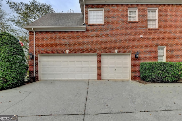 3565 Hickory Branch Trl, Suwanee, GA 30024 - back of property with concrete driveway, brick siding, an attached garage, and a shingled roof