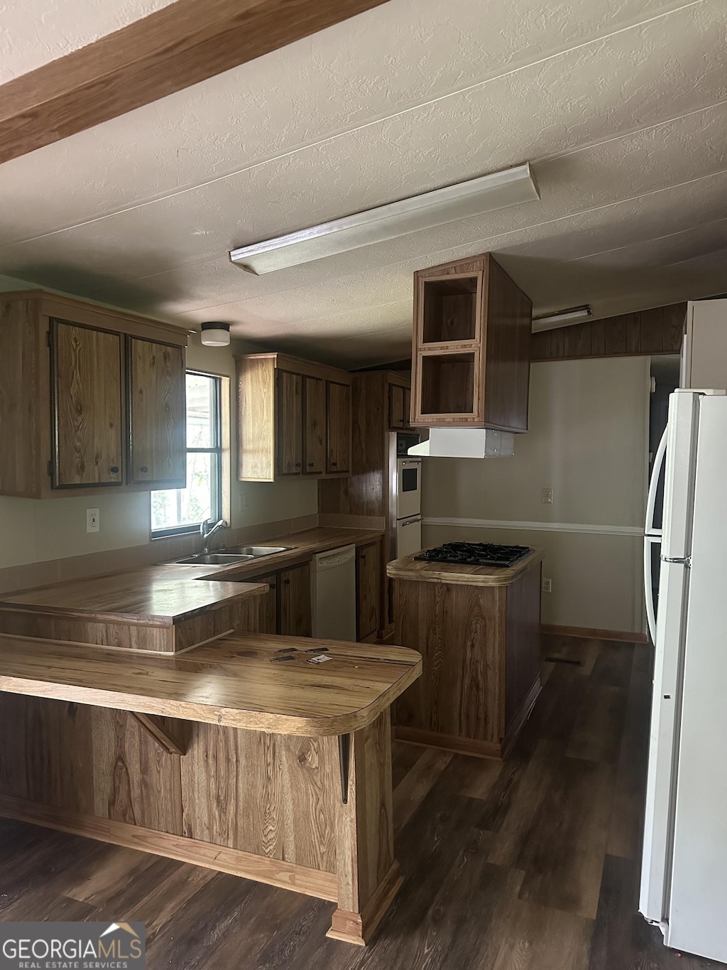 710 Seals Rd, Dallas, GA 30157 - kitchen with white appliances, a sink, dark wood-style floors, a peninsula, and exhaust hood