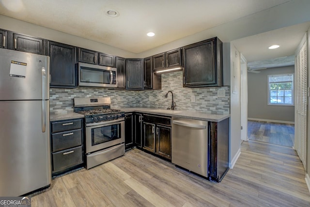 302 Atlanta Ave SE, Atlanta, GA 30315 - kitchen featuring stainless steel appliances, a sink, light wood finished floors, decorative backsplash, and baseboards