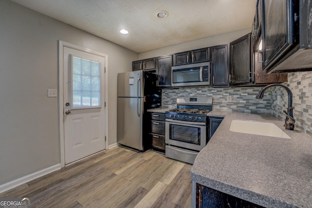 302 Atlanta Ave SE, Atlanta, GA 30315 - kitchen with appliances with stainless steel finishes, a sink, tasteful backsplash, light wood finished floors, and baseboards