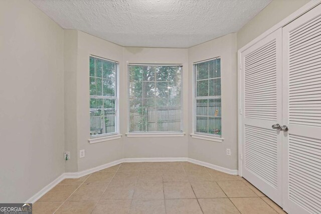 2907 Oakvale Falls Dr, Decatur, GA 30034 - unfurnished sunroom with tile patterned floors, a textured ceiling, and baseboards