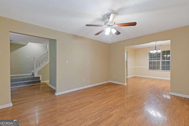 2907 Oakvale Falls Dr, Decatur, GA 30034 - unfurnished room with a chandelier, a ceiling fan, stairs, light wood-style flooring, and baseboards