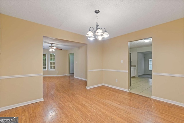 2907 Oakvale Falls Dr, Decatur, GA 30034 - spare room featuring light wood-style flooring, a chandelier, a textured ceiling, ceiling fan, and baseboards