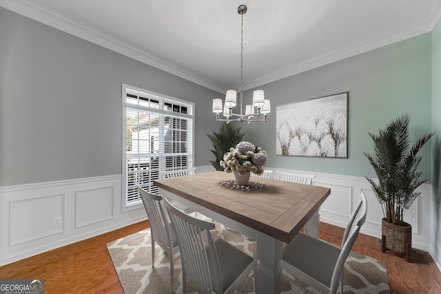 1151 Emperor Ln, Hoschton, GA 30548 - dining space featuring a chandelier, wainscoting, crown molding, and wood finished floors