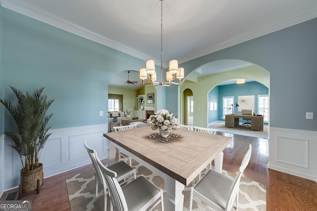 1151 Emperor Ln, Hoschton, GA 30548 - dining space with plenty of natural light, a wainscoted wall, arched walkways, dark wood-style floors, and crown molding