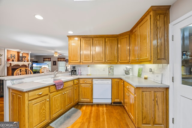 1112 Reno Rd, Royston, GA 30662 - kitchen with dishwasher, a sink, a peninsula, light wood-style flooring, and backsplash