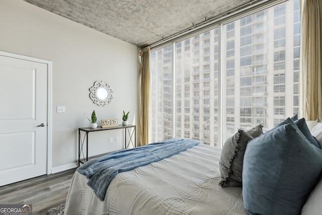 bedroom with wood finished floors and baseboards