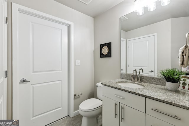 half bathroom with vanity, tile patterned flooring, and toilet