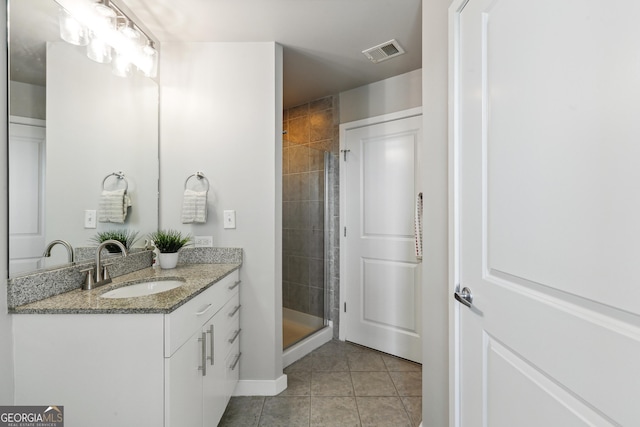 bathroom with tile patterned flooring, vanity, and a shower stall