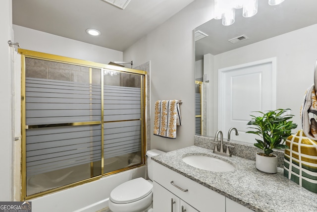 full bath with vanity, bath / shower combo with glass door, and toilet