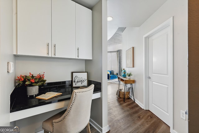 kitchen featuring dark wood finished floors, white cabinets, dark countertops, and baseboards