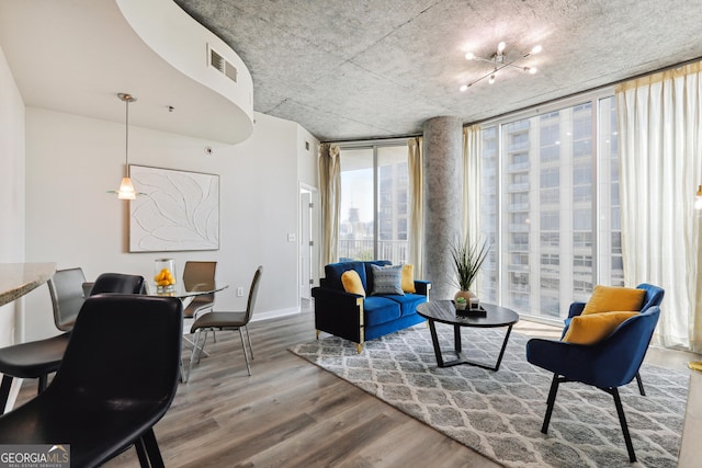 living area featuring floor to ceiling windows, wood finished floors, and baseboards