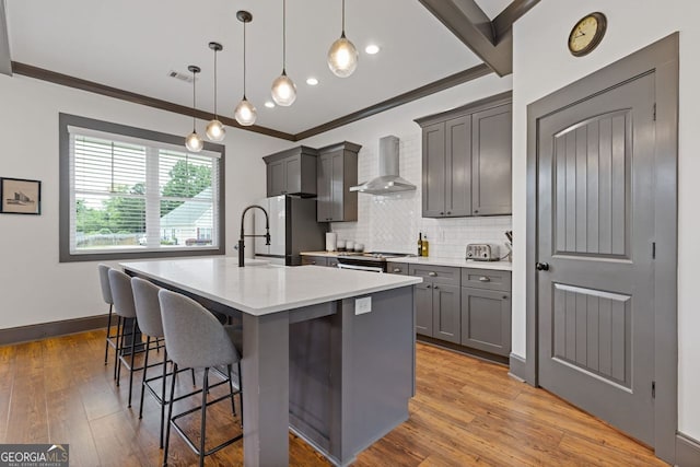 47 Wicklow Ct, Hoschton, GA 30548 - kitchen featuring wall chimney exhaust hood, freestanding refrigerator, a kitchen island with sink, tasteful backsplash, and a kitchen bar