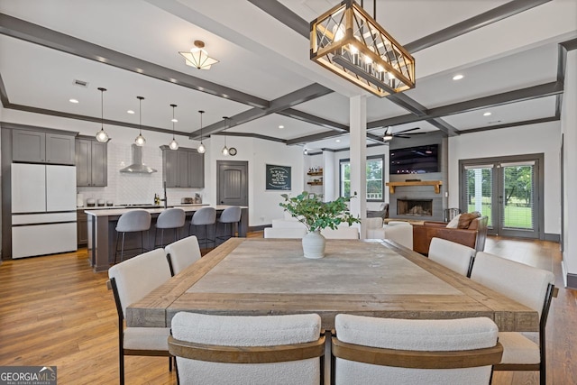 47 Wicklow Ct, Hoschton, GA 30548 - dining room with light wood-type flooring, beamed ceiling, ceiling fan, a fireplace with raised hearth, and recessed lighting