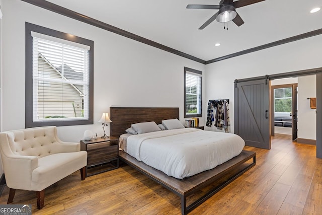 47 Wicklow Ct, Hoschton, GA 30548 - bedroom featuring a barn door, crown molding, multiple windows, hardwood / wood-style flooring, and recessed lighting