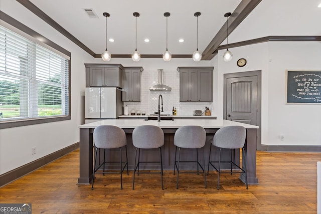 47 Wicklow Ct, Hoschton, GA 30548 - kitchen with freestanding refrigerator, light countertops, a kitchen island with sink, tasteful backsplash, and a breakfast bar area