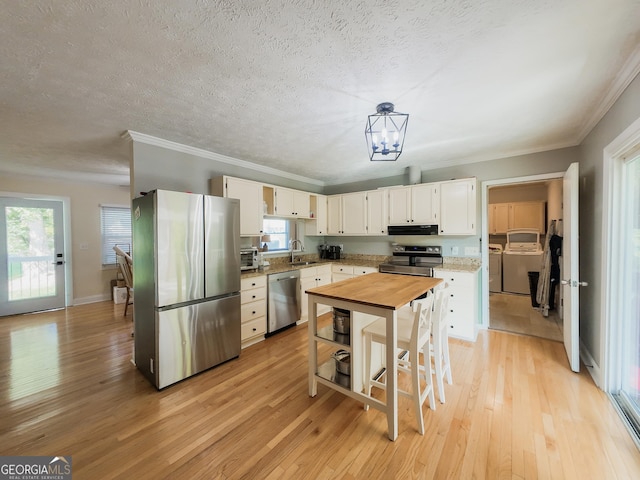 3905 Hunt Dr, Gainesville, GA 30507 - kitchen with appliances with stainless steel finishes, light wood-type flooring, ornamental molding, a chandelier, and white cabinets