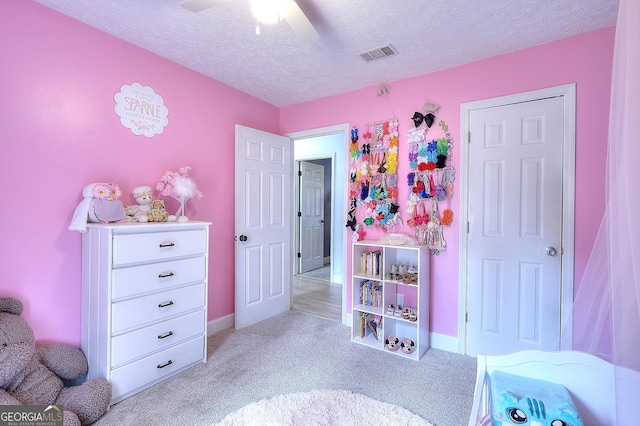bedroom featuring light carpet, a textured ceiling, baseboards, and ceiling fan
