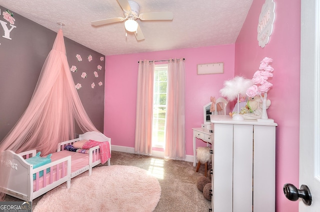 carpeted bedroom with a textured ceiling, baseboards, and ceiling fan