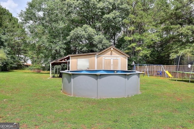view of yard with a trampoline, a playground, and view of scattered trees