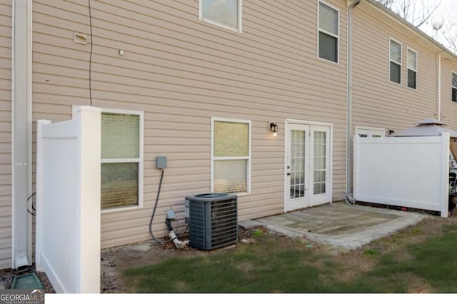 rear view of property with central air condition unit and a patio