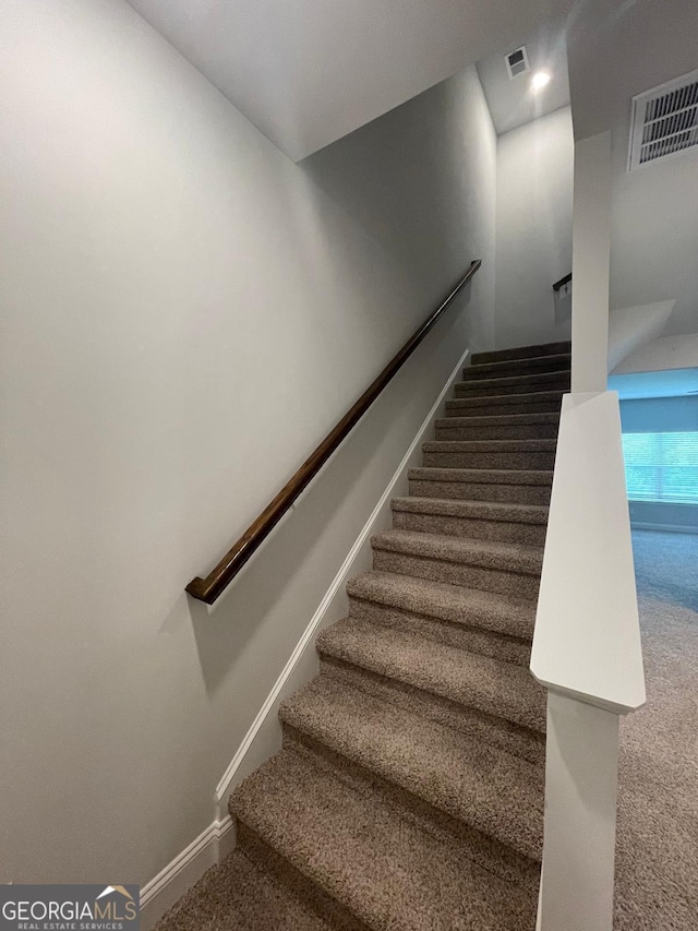 staircase featuring carpet flooring and baseboards