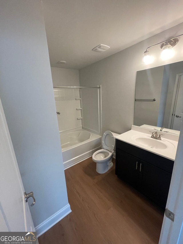 bathroom featuring wood finished floors, vanity, toilet, and shower / tub combination