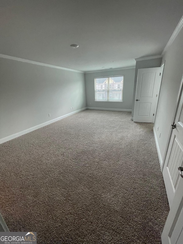 carpeted empty room featuring ornamental molding and baseboards