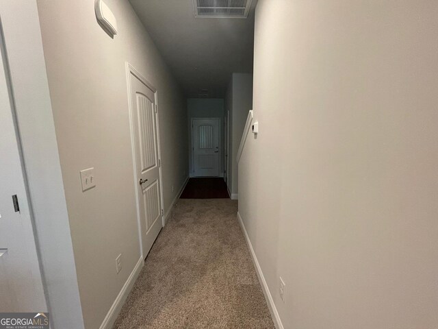 corridor with carpet floors and baseboards