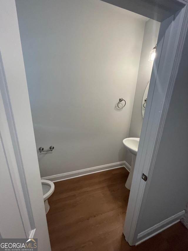 bathroom with wood finished floors and baseboards