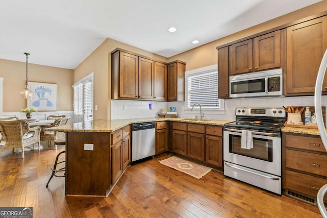 1050 Cobblestone Ln, Bogart, GA 30622 - kitchen with stainless steel appliances, a peninsula, plenty of natural light, backsplash, and recessed lighting