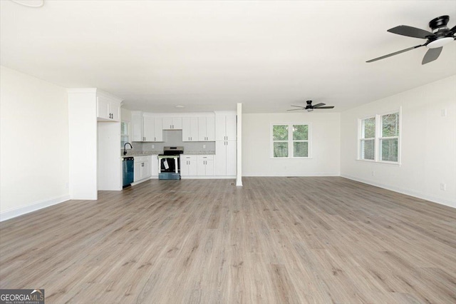 unfurnished living room featuring a ceiling fan, light wood-type flooring, and baseboards