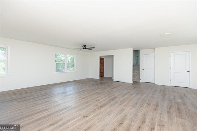 unfurnished living room featuring light wood-style floors, ceiling fan, and baseboards
