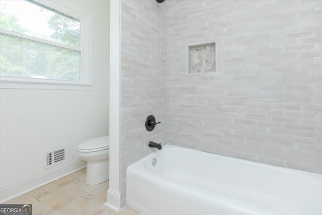 bathroom with baseboards, toilet, and shower / washtub combination