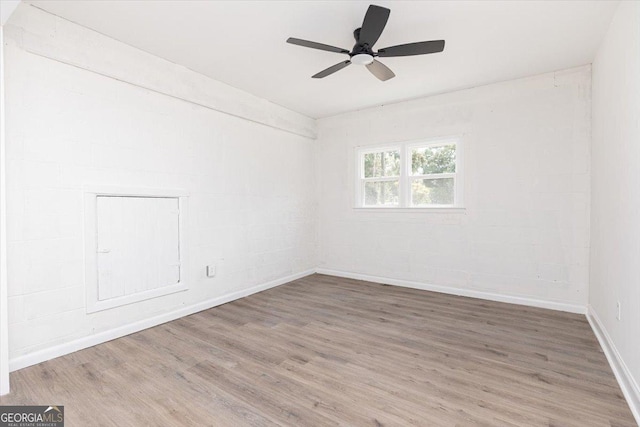 empty room featuring wood finished floors, ceiling fan, and baseboards