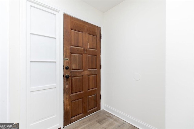 foyer entrance with light wood-style flooring and baseboards