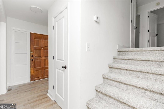 stairs featuring wood finished floors