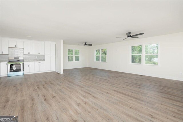 unfurnished living room featuring a ceiling fan, light wood-style floors, and baseboards