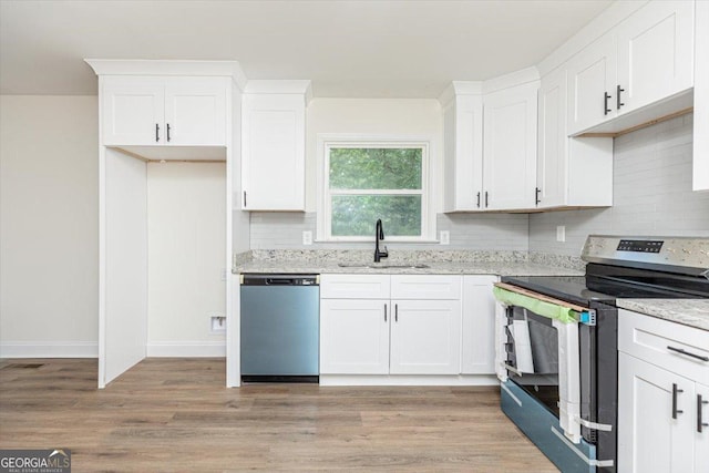 kitchen featuring appliances with stainless steel finishes, a sink, tasteful backsplash, and white cabinetry