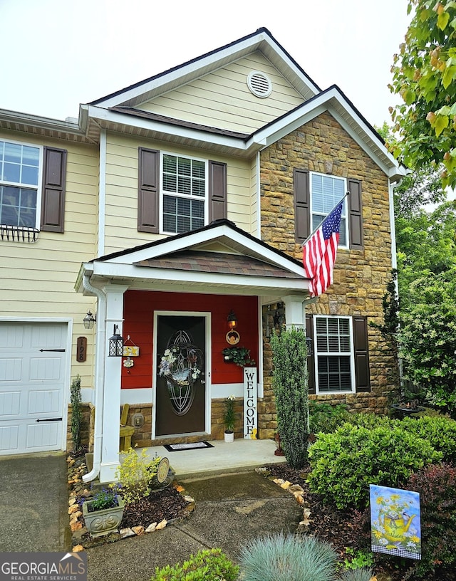 view of front facade with stone siding and a garage