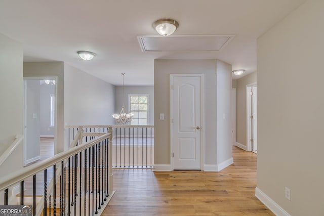 351 Chandler Bluff Ct, Grayson, GA 30017 - hall with attic access, light wood-type flooring, a chandelier, and baseboards